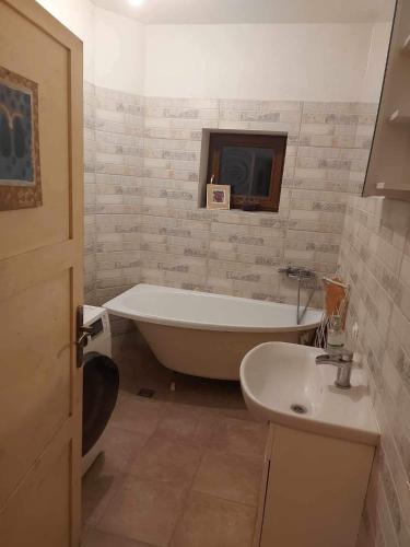 a bathroom with a bath tub and a sink at Balto kalno namai, Kernavėje in Kernavė