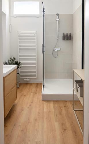 a bathroom with a shower and a wooden floor at Suites am Herzogberg in Brunn am Gebirge