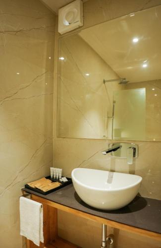 a bathroom with a white sink and a mirror at DHANUSH STAYS - A Boutique Accommodation in Varanasi