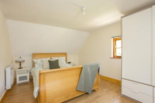 a bedroom with a bed and a mirror at Dulcie's Cottage in Wootton