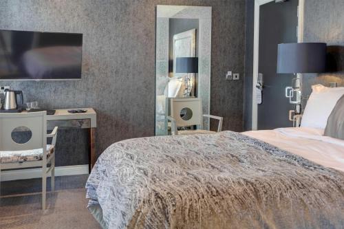a bedroom with a bed and a desk and a mirror at The Bold Hotel; BW Signature Collection in Southport