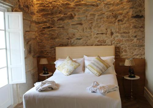 a bedroom with a bed with towels on it at Hospedium Hotel Barómetro de Camariñas in Camariñas