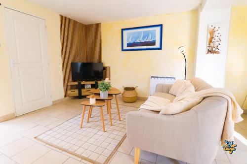 a living room with a couch and a tv at Côte et Mer in Wissant
