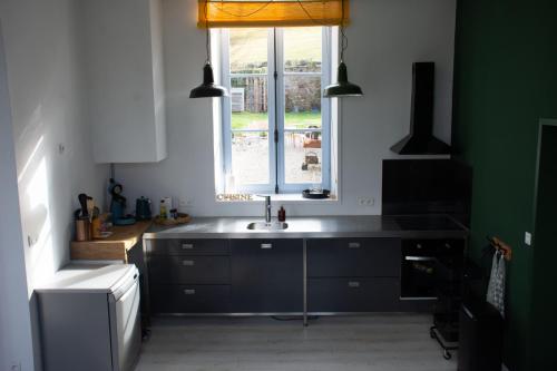 a kitchen with a sink and a window at L' Ancienne Ecole du Morvan in Larochemillay