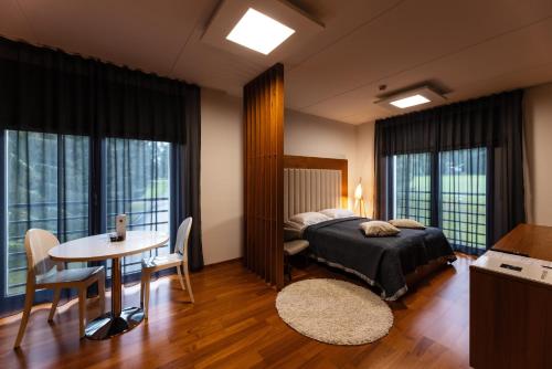 a bedroom with a bed and a table and chairs at GMP Clubhotel Apartments in Otepää