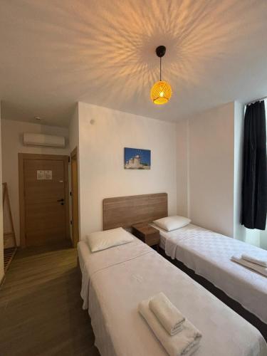 a hotel room with two beds and a chandelier at Kırçak Konak in Çeşme