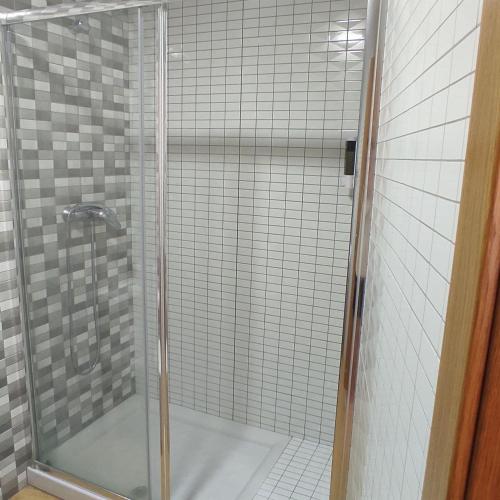 a shower with a glass door in a bathroom at Malpica I in Malpica