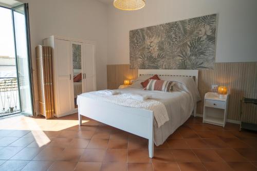a bedroom with a large white bed with two lamps at Open Space Suite in the Center of Salerno, modern apartment into Historic District, 250 meters from seafront and 20 meters from the Main Street Corso Garibaldi in Salerno