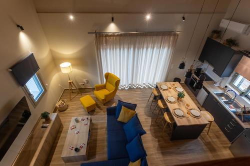 a living room with a table and a yellow chair at Sarantou House in Koroni