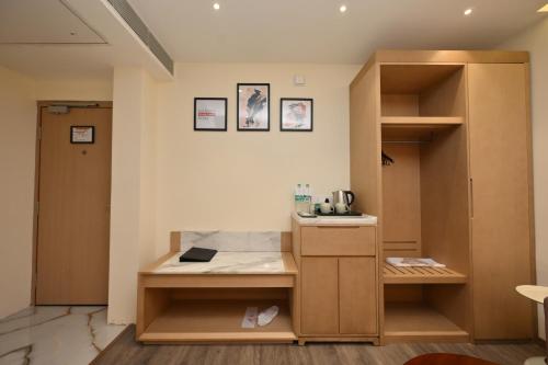 a room with a desk and a book shelf at The Park Inn in Jhārsuguda