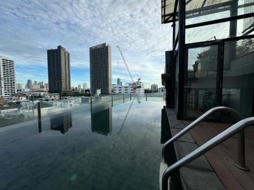 a building with a pool of water in a city at W8 Condo, LUXE 2 Bedroom Private floor, Best Hip Central Bangkok area, 5 mins from Thonglo BTS station in Bangkok