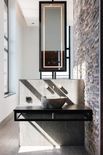 a bathroom with a stone sink and a mirror at Van der Valk Hotel Houten Utrecht in Houten