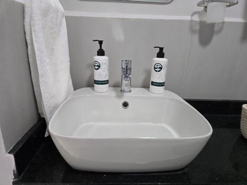 a white sink in a bathroom with two bottles on it at Oloisiri Namanga Hotel in Namanga