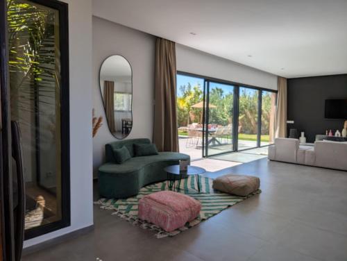 a living room with a green couch and a mirror at Villa LaLa in Marrakesh