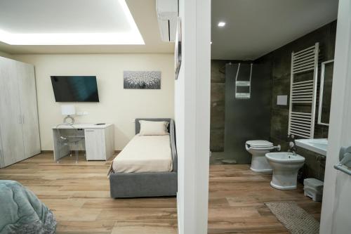 a bedroom with a bed and a toilet and a sink at Xenia in Crotone
