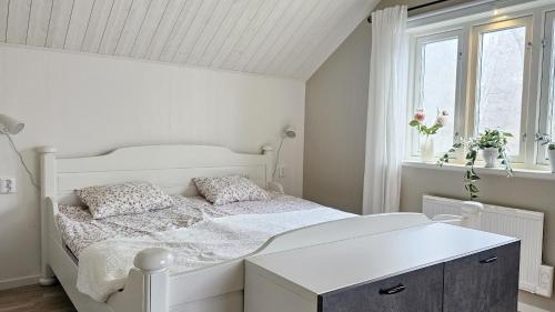 a white bedroom with a white bed and a window at Two cozy accommodations near the sea SE09118 in Gåseknöde
