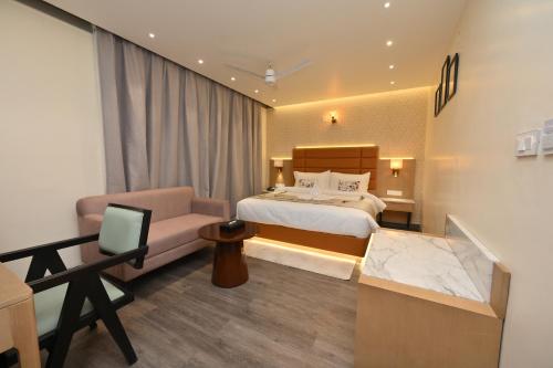 a hotel room with a bed and a couch at The Park Inn in Jhārsuguda