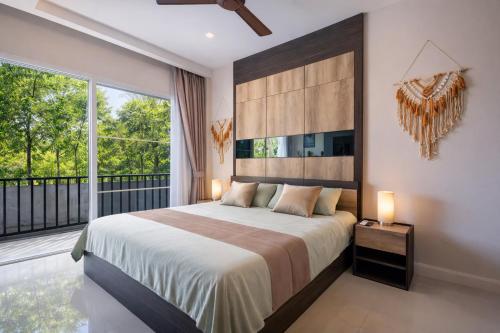 a bedroom with a large bed and a balcony at Condo Vireo Pool View Rawai in Phuket