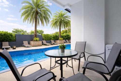 a patio with a table and chairs next to a swimming pool at Condo Vireo Pool View Rawai in Phuket