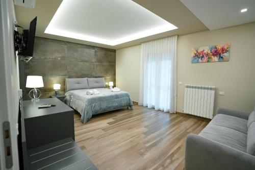 a bedroom with a bed and a tv and a couch at Xenia in Crotone