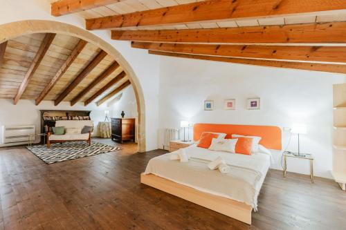 a bedroom with a large bed in a room with wooden ceilings at Calvario Townhouse by rentavillamallorca in Pollença