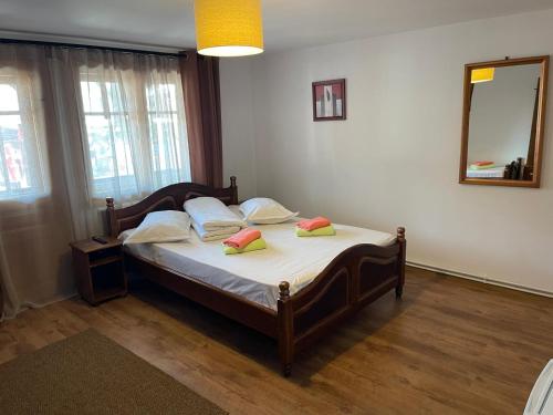 a bedroom with a bed with two pillows and a mirror at La Ceaune & Hanul Ceaunelor Voronet in Voronet