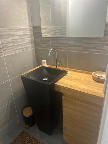 a bathroom with a black sink and a mirror at Don Quichotte in Vallet