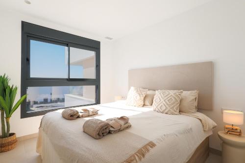 a bedroom with a large bed with towels on it at Nieuw Casa Santa Rosalia uitzicht op zwembad in Torre-Pacheco