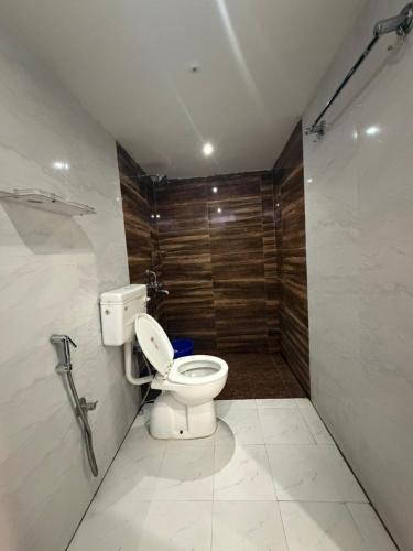 a bathroom with a toilet and a wooden wall at Jogi Lodge in Varanasi