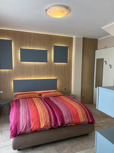 a bedroom with a large bed with a colorful blanket at Villa dei Roveri in Tignale