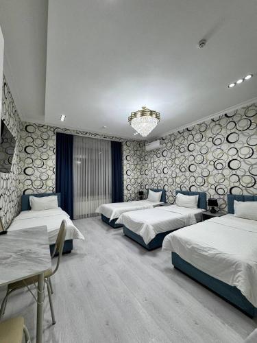 a hotel room with three beds and a chandelier at Emirate Plaza in Sergeli