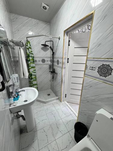 a white bathroom with a shower and a sink at Emirate Plaza in Sergeli