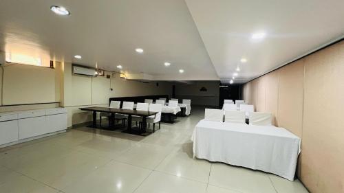 a dining room with white tables and white chairs at Aadhar Hotel in Gurgaon