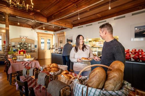 a man and woman standing in a bakery with baskets of bread at Hotel Schynige Platte in Wilderswil