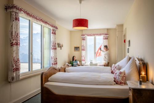 a bedroom with two beds and a window at Hotel Schynige Platte in Wilderswil