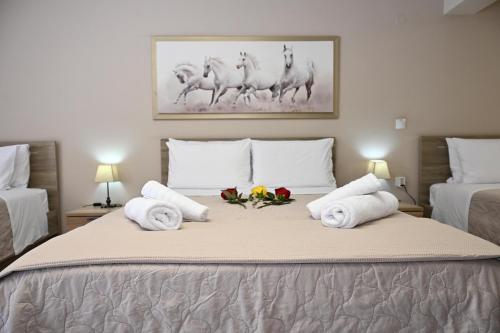 ein Schlafzimmer mit einem Bett, darauf Handtücher und Blumen in der Unterkunft Hotel Vasilis Nafplio in Nafplio