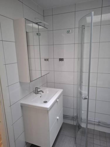 a white bathroom with a sink and a mirror at Workers Stay - Construction Worker Housing in Gothenburg
