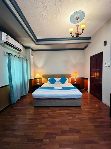 a bedroom with a bed and a chandelier at Bab Al Bahrain Hotel in Manama
