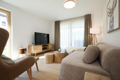a living room with a couch and a tv at Alpenlodge LEO in Mittenwald