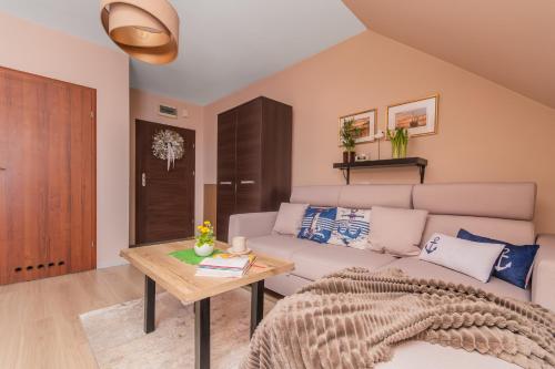 a living room with a couch and a table at Apartament P27 in Sztutowo