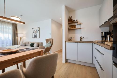 a kitchen and living room with a table and chairs at Alpenlodge LEO in Mittenwald