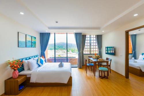 a hotel room with a bed and a table and chairs at The Sea Light Hotel Phú Quốc- Sunset and Ocean View in Phú Quốc
