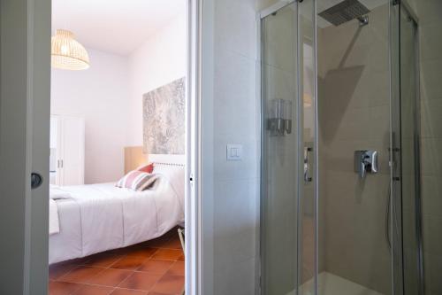a bathroom with a shower and a bed in a room at Open Space Suite in the Center of Salerno, modern apartment into Historic District, 250 meters from seafront and 20 meters from the Main Street Corso Garibaldi in Salerno