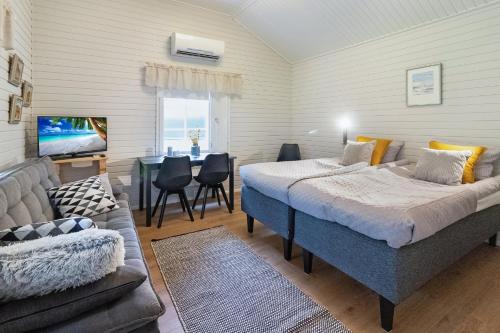 a bedroom with two beds and a couch and a table at Villa Lepola Sauna Suite in Rovaniemi
