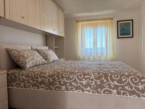 a bedroom with a bed and a window at Apartman Karla in Selce