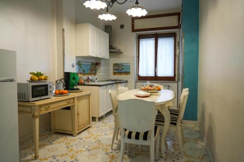 a kitchen with a table and chairs and a microwave at Bellavista Costa d'Amalfi in Vietri sul Mare