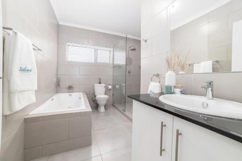 a white bathroom with a sink and a toilet at Uitzicht in Springbok