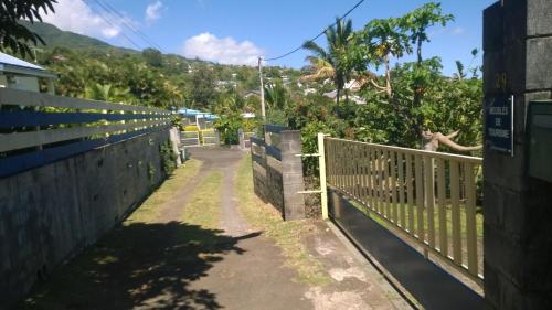 a fence on the side of a road at Les Bungalows du Mont-Auban in Sainte-Clotilde