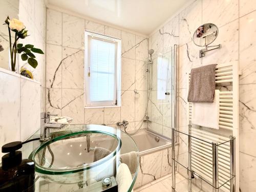 a bathroom with a glass tub and a shower at Boutique Hotel Villa am See in Hagnau