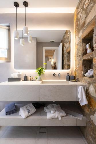 a bathroom with a sink and a large mirror at Miles Away Residences in Platis Gialos